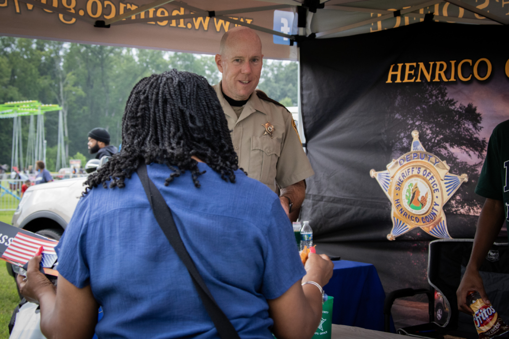 Sheriff's officer talking to a civilian in an outreach event