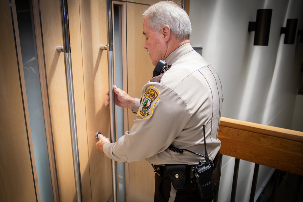 Sheriff's office officer locking doors to court room